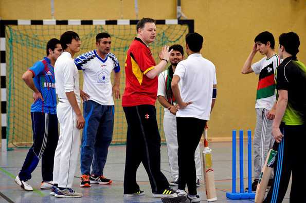 Brian Mantle (C), ประธาน Deutscher Cricket Bund (DCB) ดูแลการฝึกอบรมกับผู้ลี้ภัยจากอัฟกานิสถานใน Essen, เยอรมนีตะวันตก.